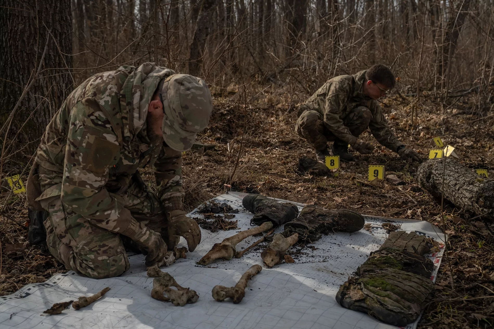 Oleksii Yukov arranges the bones of a Russian soldier that were found on an anatomical banner