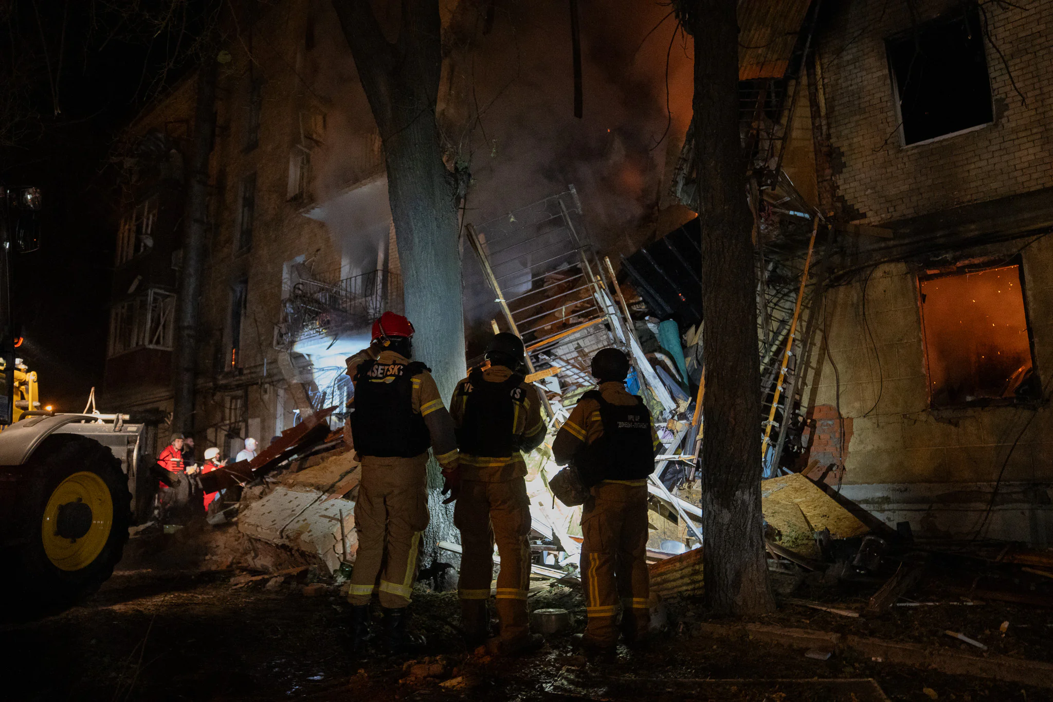 Firefighters are watching the fire in a destroyed apartment building in Kharkiv