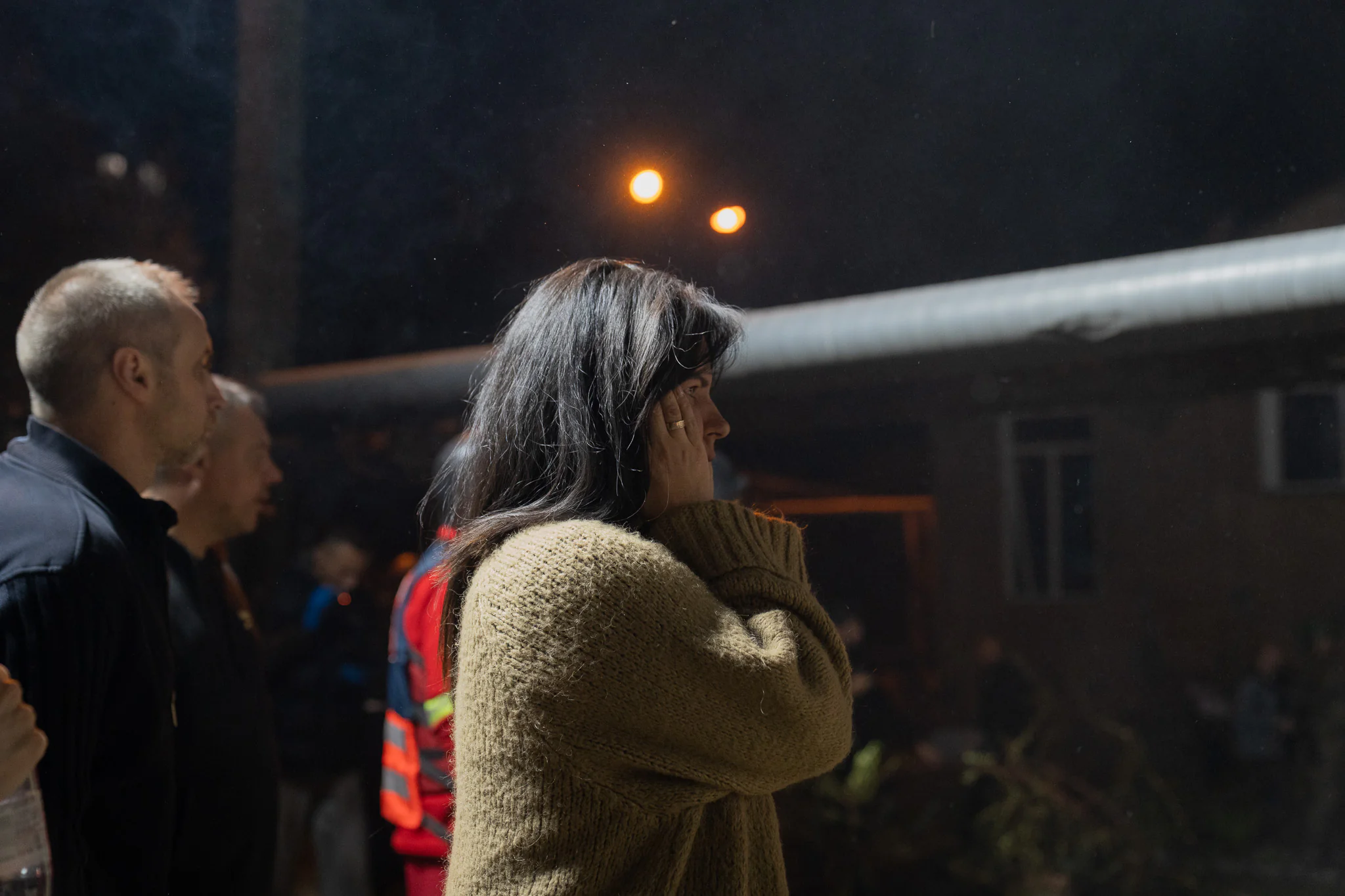 A local watches as rescue workers clear the rubble in Kharkiv